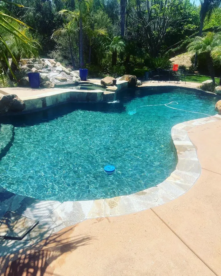 Customer's rock-edge pool with clear blue water